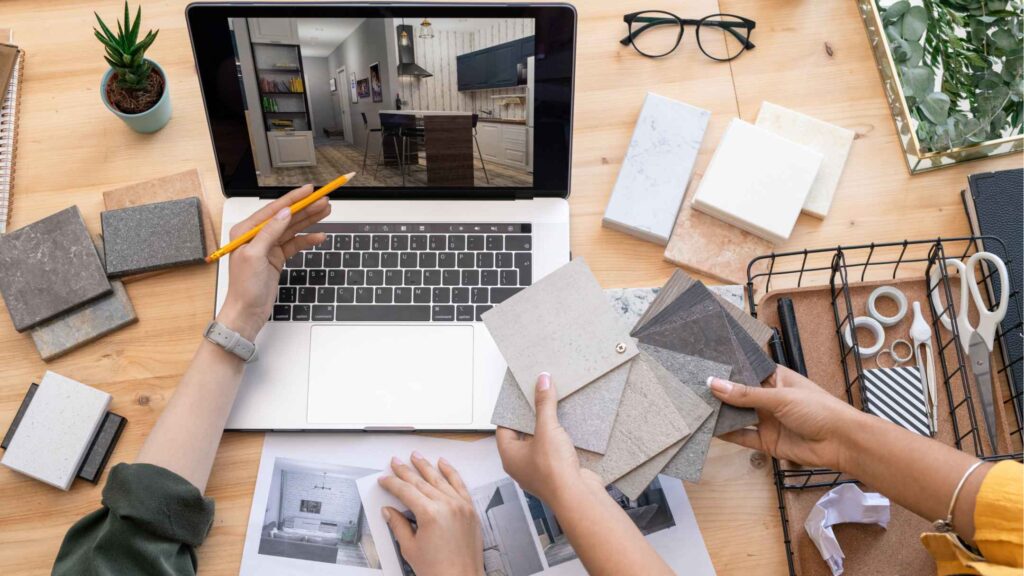 Une personne travaille sur un ordinateur portable avec une image d'une maison affichée à l'écran.