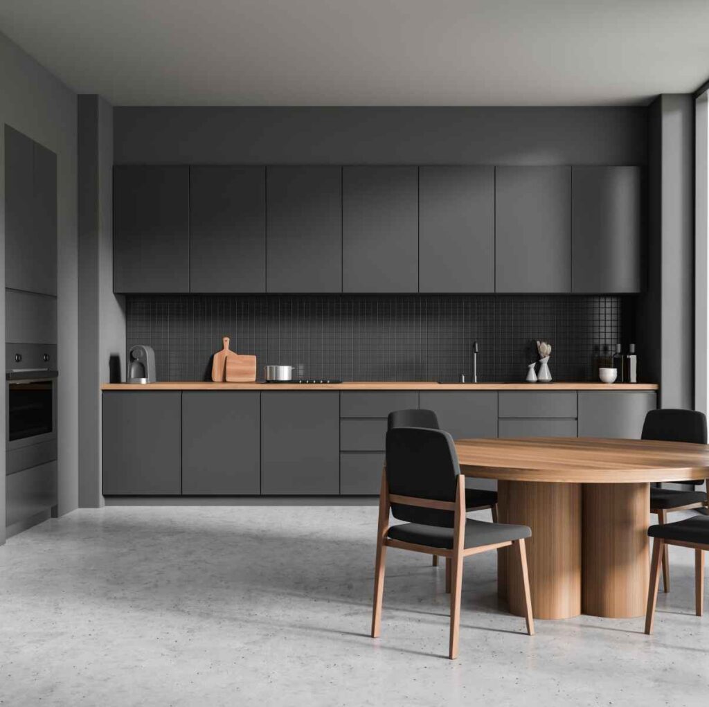 Cuisine moderne avec des armoires noires et une table en bois.