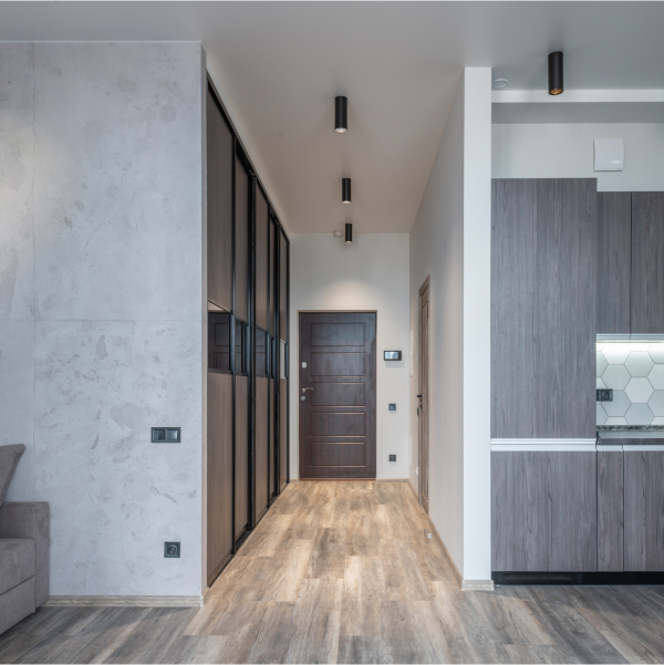 Intérieur d'appartement moderne avec parquet en bois et murs gris.
