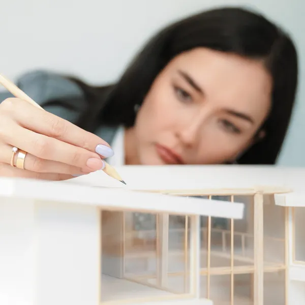 Une femme dessine un modèle de maison pour un agrandissement.