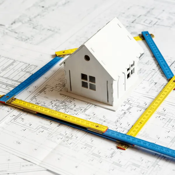 Modèle de maison et une règle sur des plans architecturaux pour un agrandissement de maison.