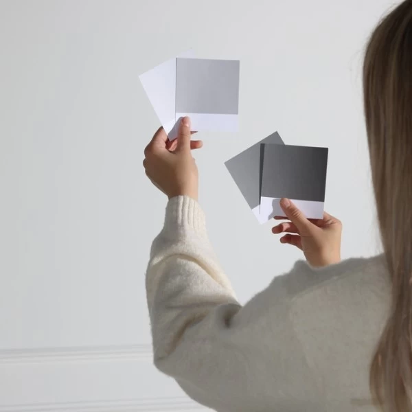 a woman holding several white and grey papers