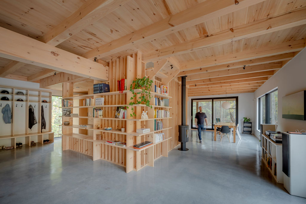 Conçue par le designer d'intérieur Frédric Clairoux, photo de l'intérieur d'une résidence de campagne au design unique d'une aire ouverte mettant en valeur bois blond et sols en epoxy.