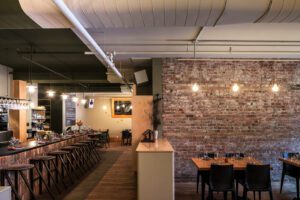 Vue sur la zone de service entre le bar et l'une des zones de salle à manger dont le design intérieur est signé par Clairoux.