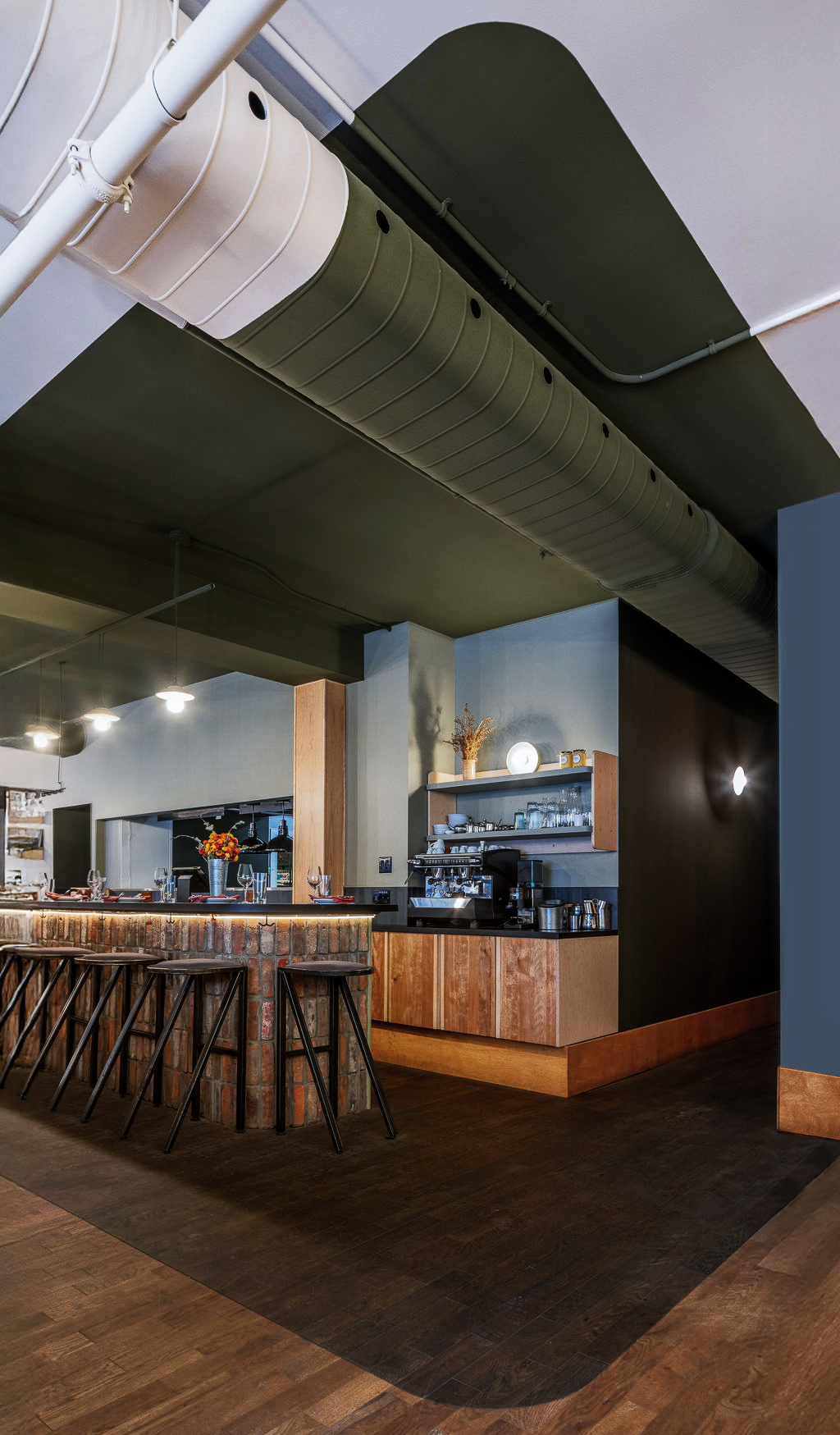 Le design intérieur de la section bar met en valeur l’utilisation de matériaux recyclés, créant une ambiance chaleureuse et accueillante. / The interior design of the bar area highlights the use of recycled materials, creating a warm and welcoming atmosphere.